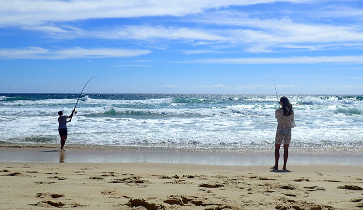 2 people fishing at beach